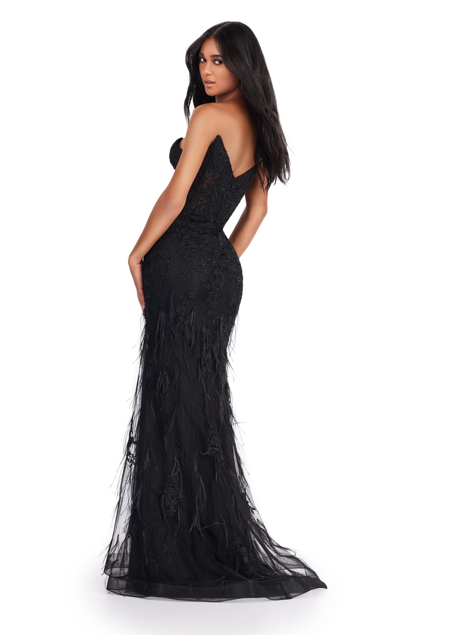 Elegant strapless black gown with a deep plunging neckline, featuring intricate beading and feather embellishments, flowing into a fitted silhouette and delicate tulle skirt.