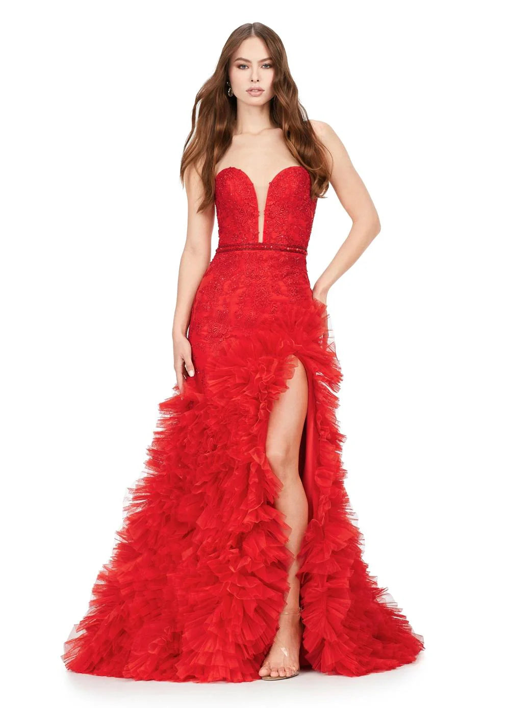 Strapless red gown with a plunging neckline, lace detailing, high slit, and a voluminous ruffled skirt cascading to a floor-length design.