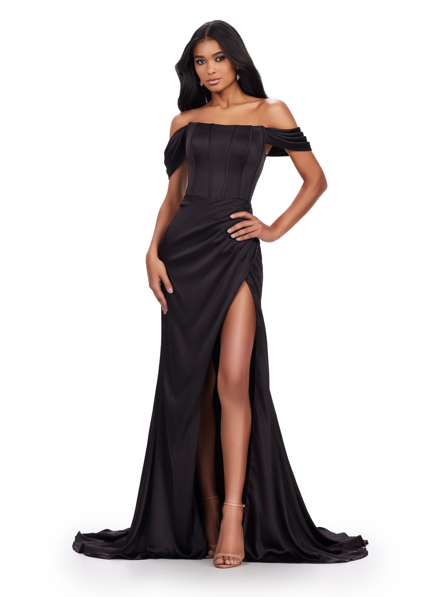 Off-the-shoulder black evening gown featuring a corset-style bodice with pleated detailing, ruffled sleeve accents, a high leg slit, and a floor-length skirt with a slight train.