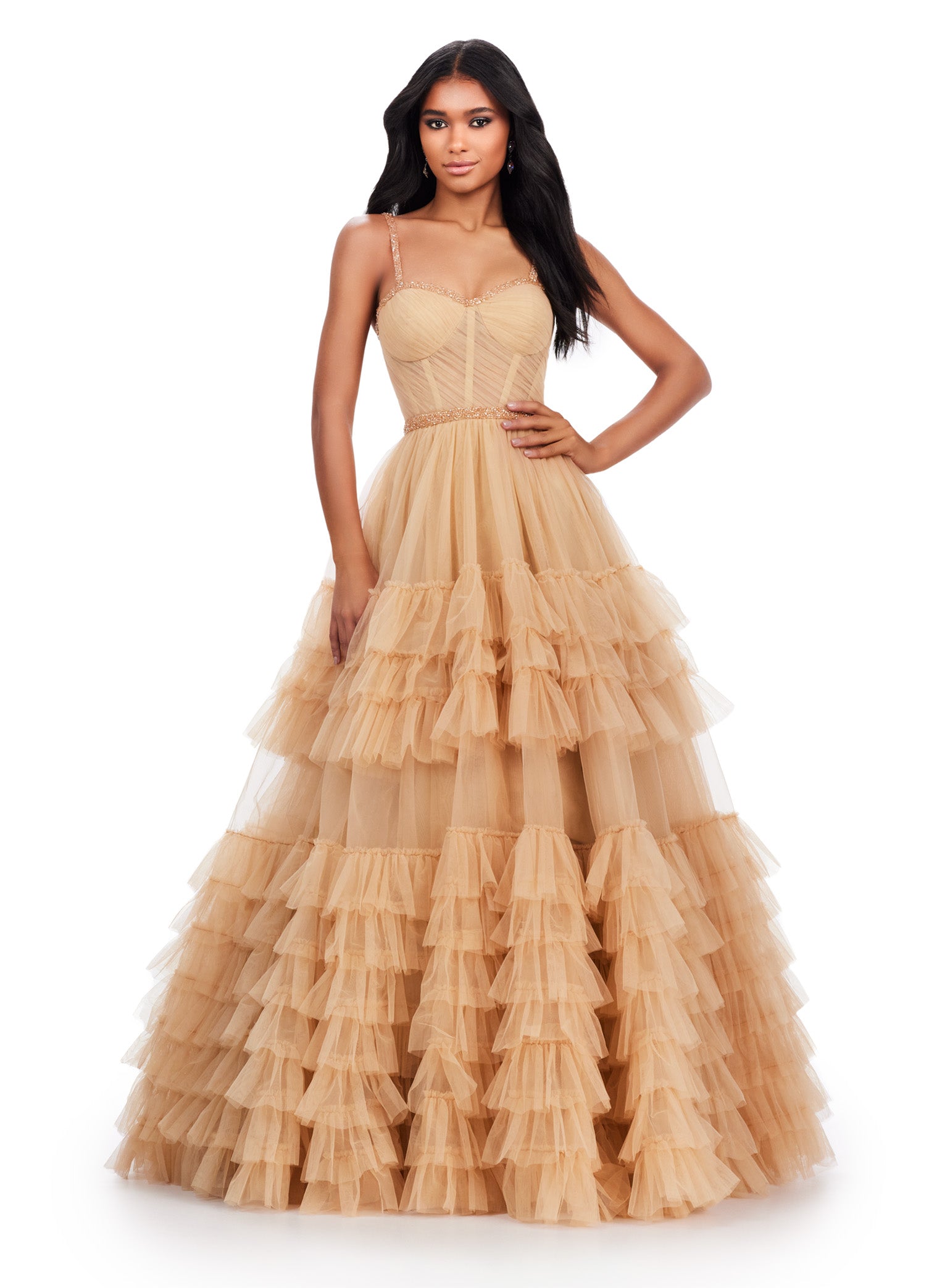 Nude ball gown with a sweetheart neckline, fitted bodice, embellished waistband, and tiered tulle skirt.