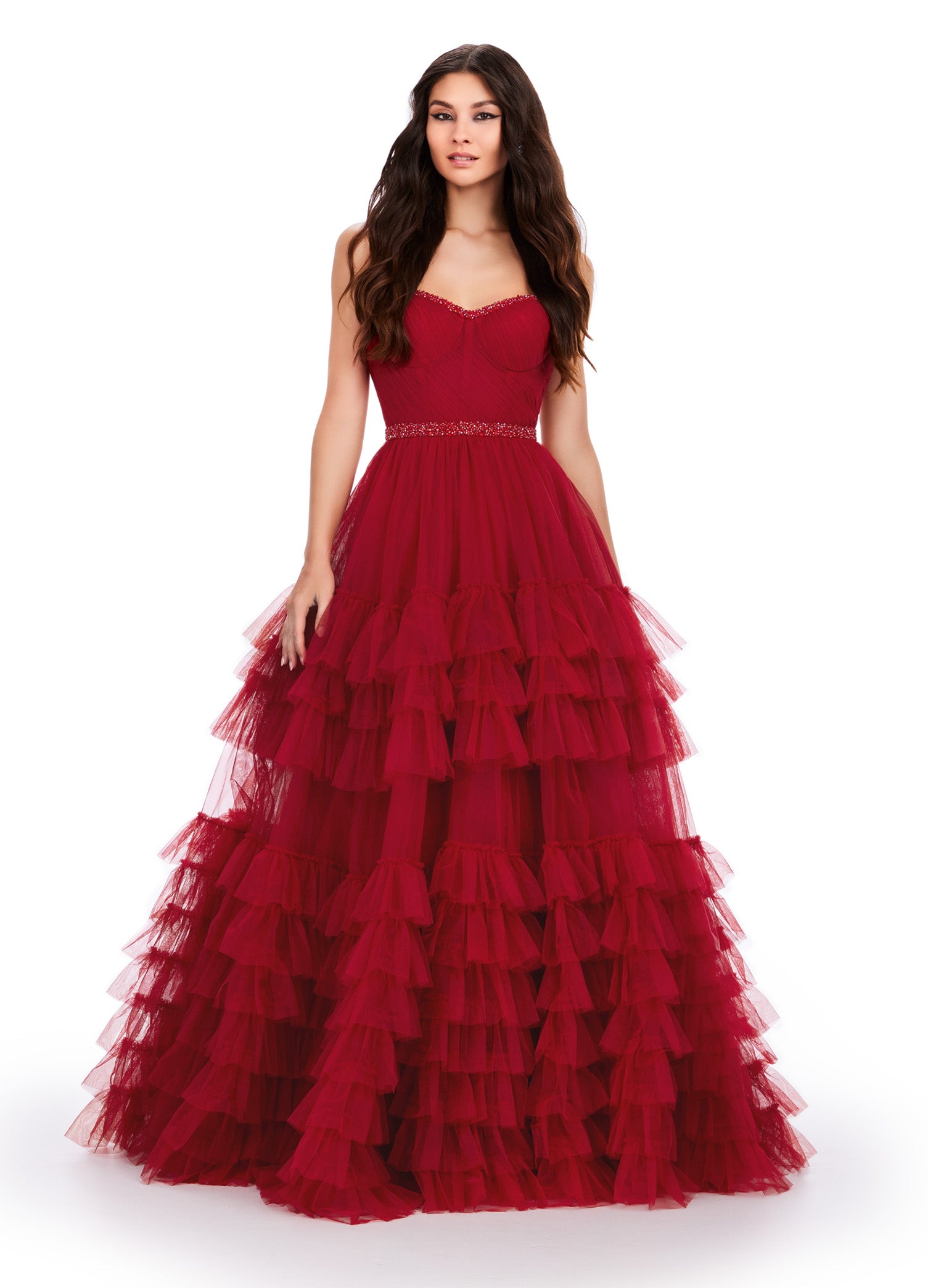 Red ball gown with a sweetheart neckline, fitted bodice, embellished waistband, and tiered tulle skirt.