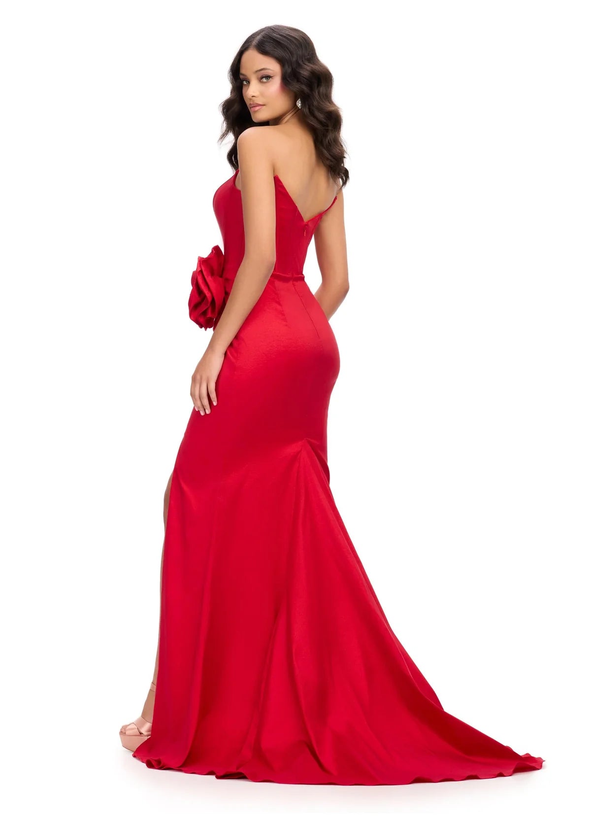 Back View - Strapless red gown with a corset-style bodice, high slit, floor-length skirt, and a large floral accent at the waist.