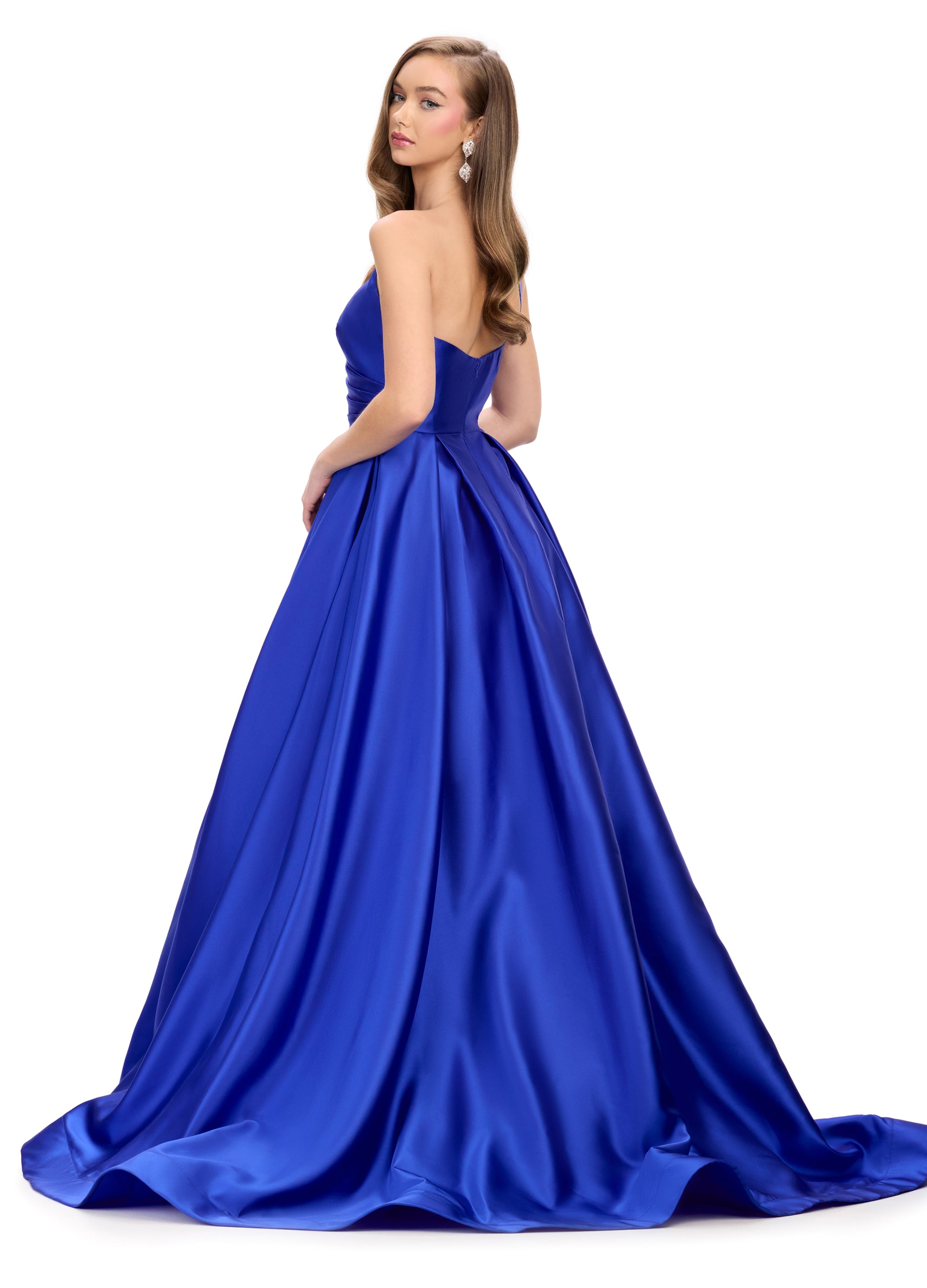 Back view of a striking royal blue ball gown with a plunging neckline, wrap-style bodice, and a dramatic full skirt, perfect for an unforgettable evening look.