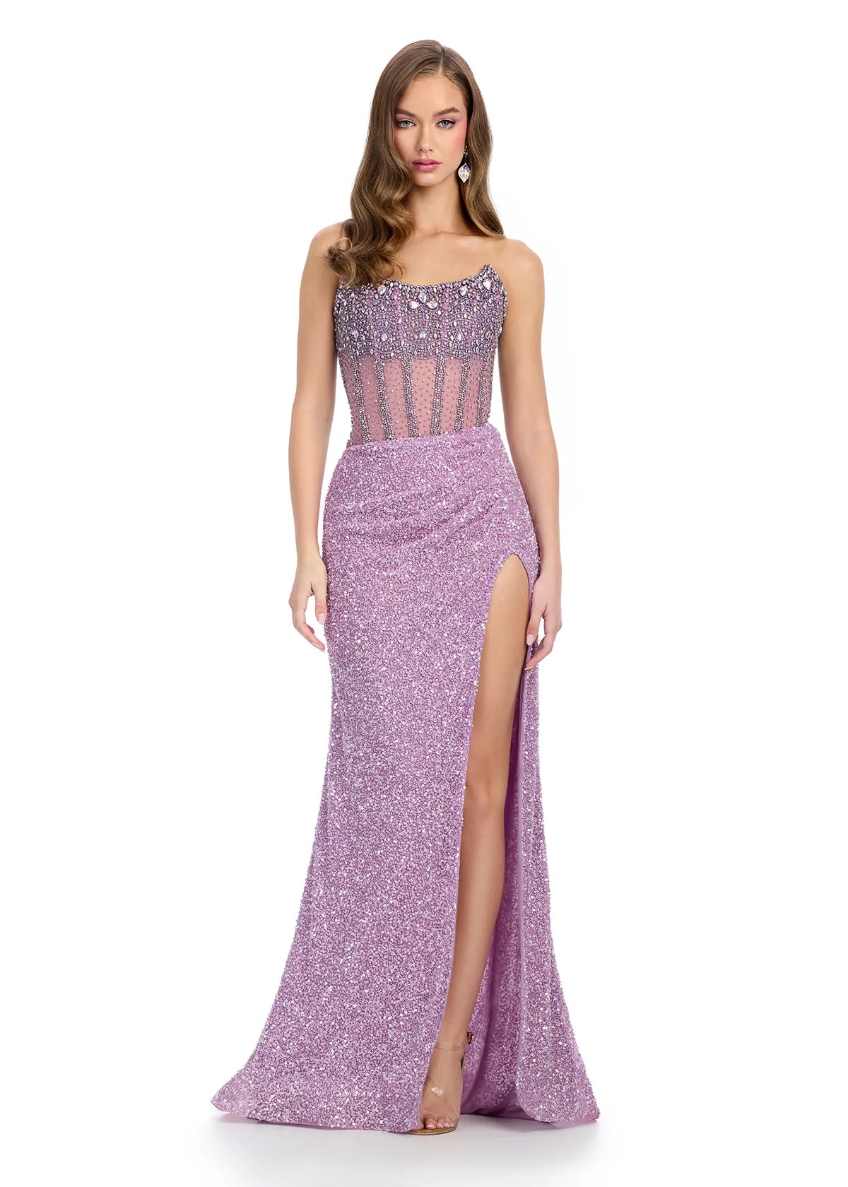 Lavender gown with a sheer embellished bodice, fitted sparkling skirt, high slit, and floor-length design.