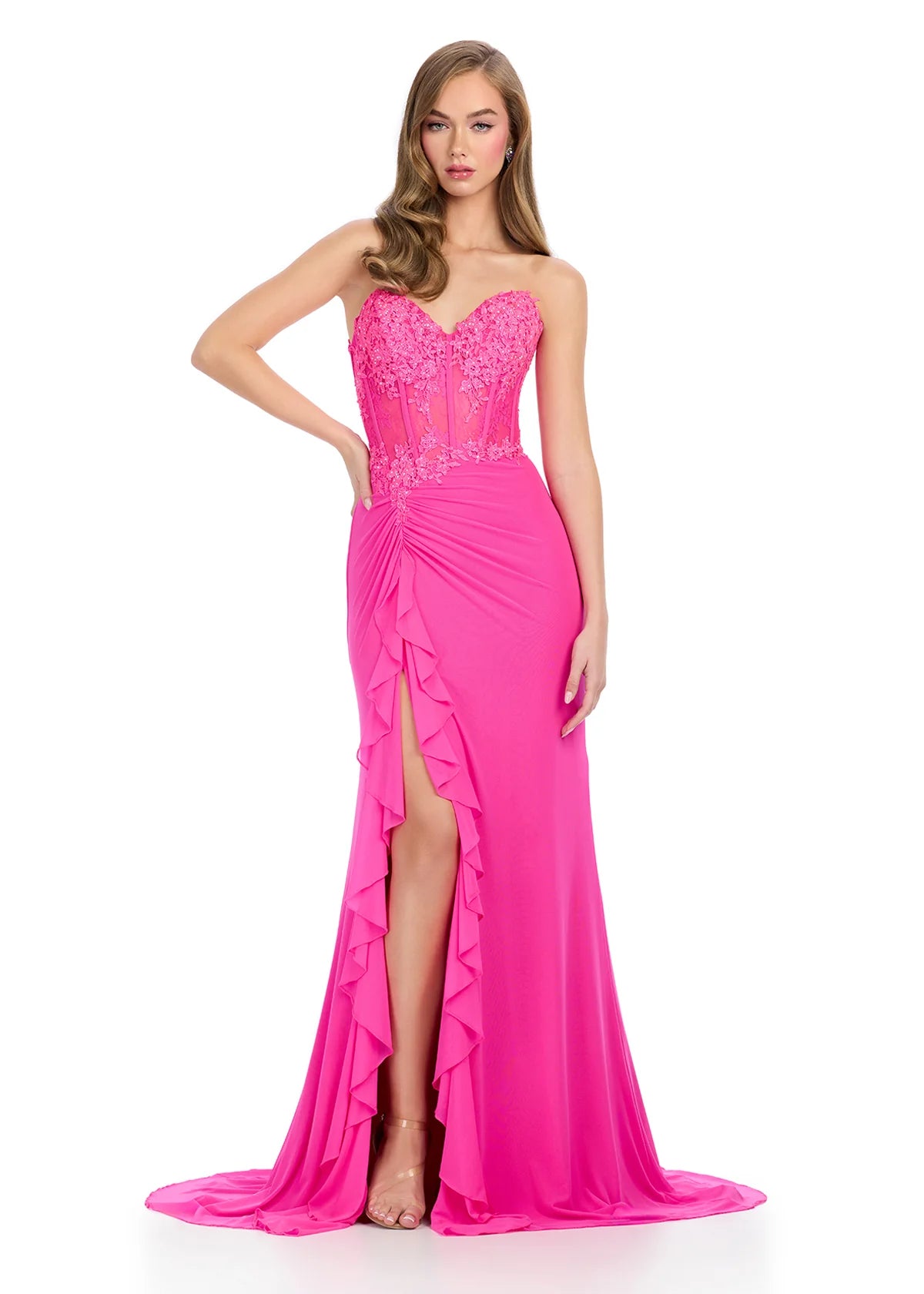 Elegant hot pink floor-length gown featuring a strapless sweetheart neckline, sheer lace bodice, ruched detailing, cascading ruffle accents, a thigh-high slit, and a flowing train for a dramatic and sophisticated look.