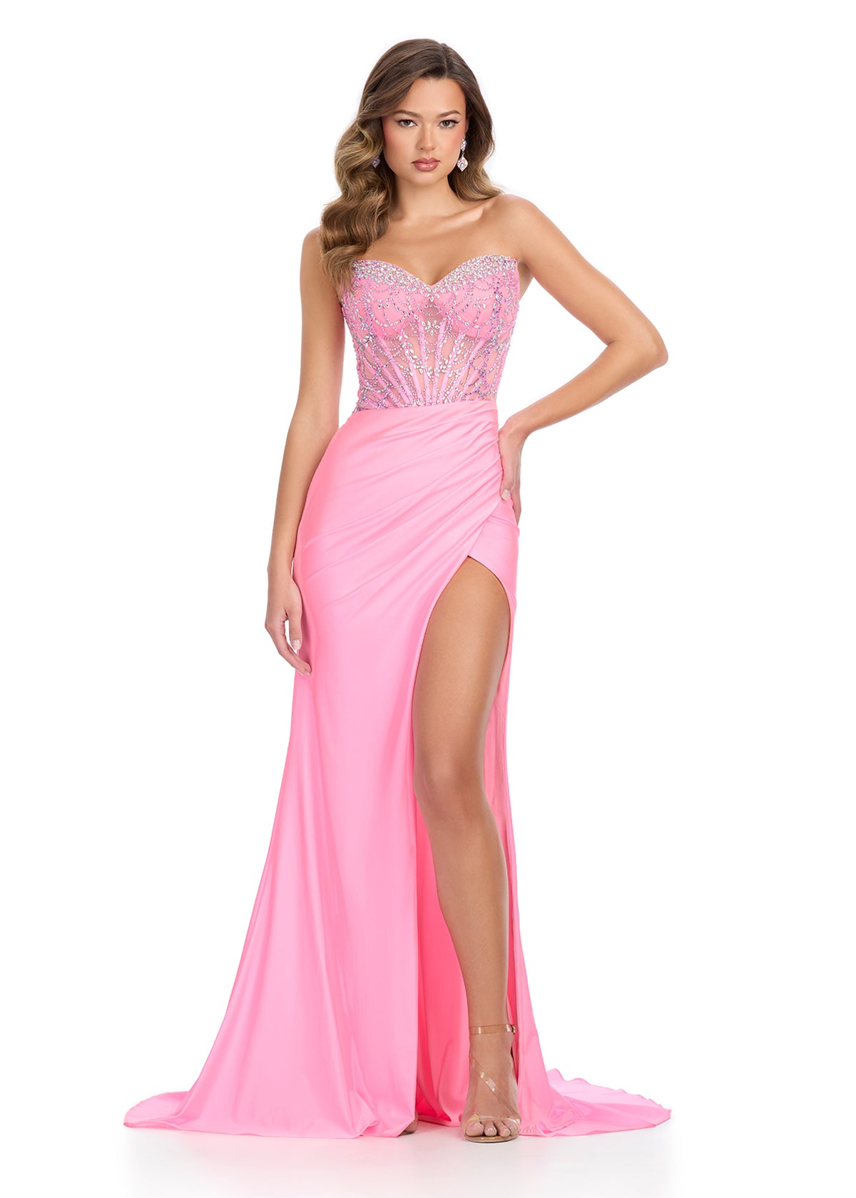 Stunning pink floor-length gown featuring a strapless sweetheart neckline, intricate beaded bodice with sheer detailing, ruched skirt, thigh-high slit, and a flowing train for a bold and elegant look.