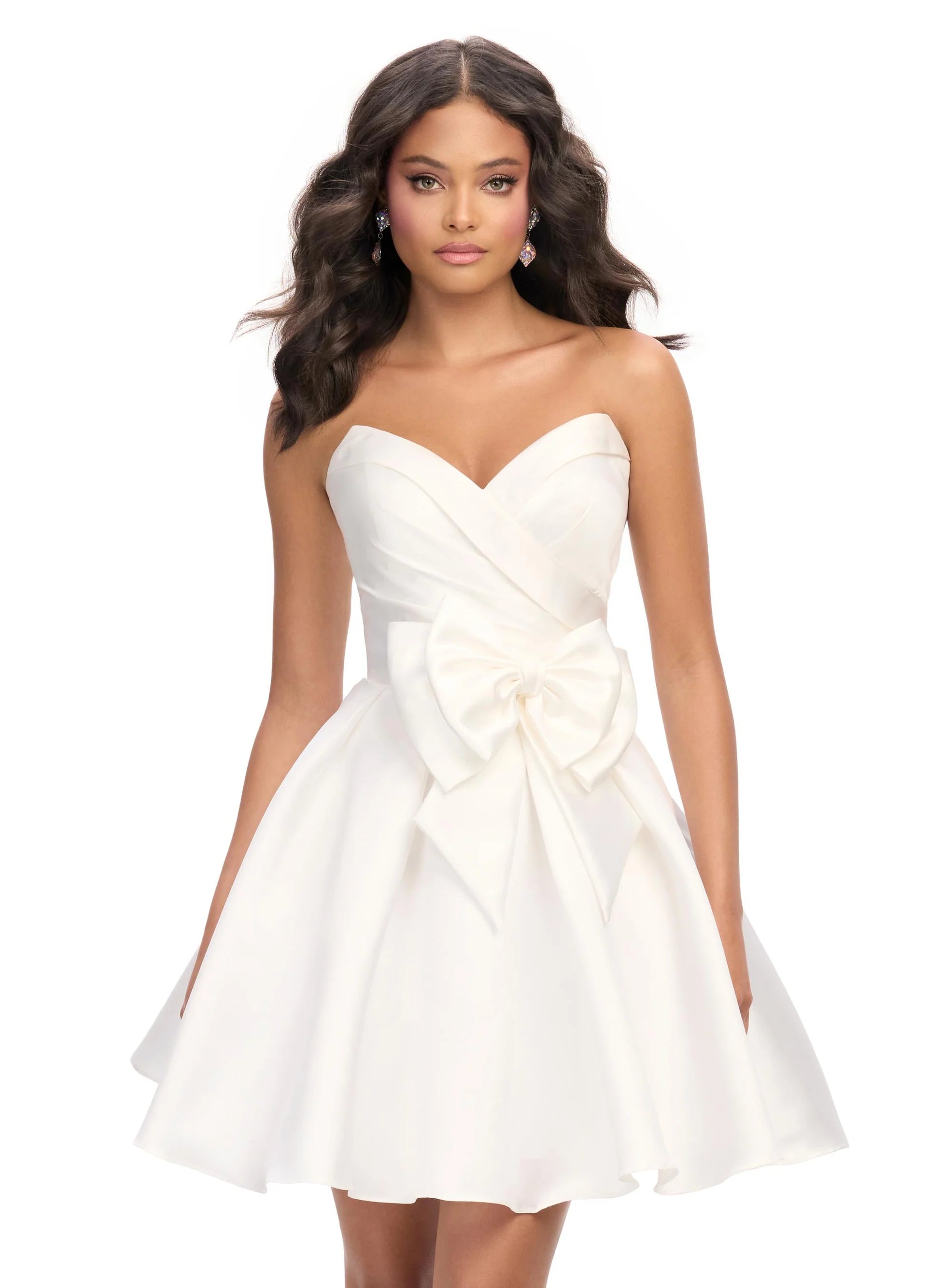 Strapless white mini dress featuring a sweetheart neckline, pleated bodice, and oversized bow accent for a playful and elegant look.