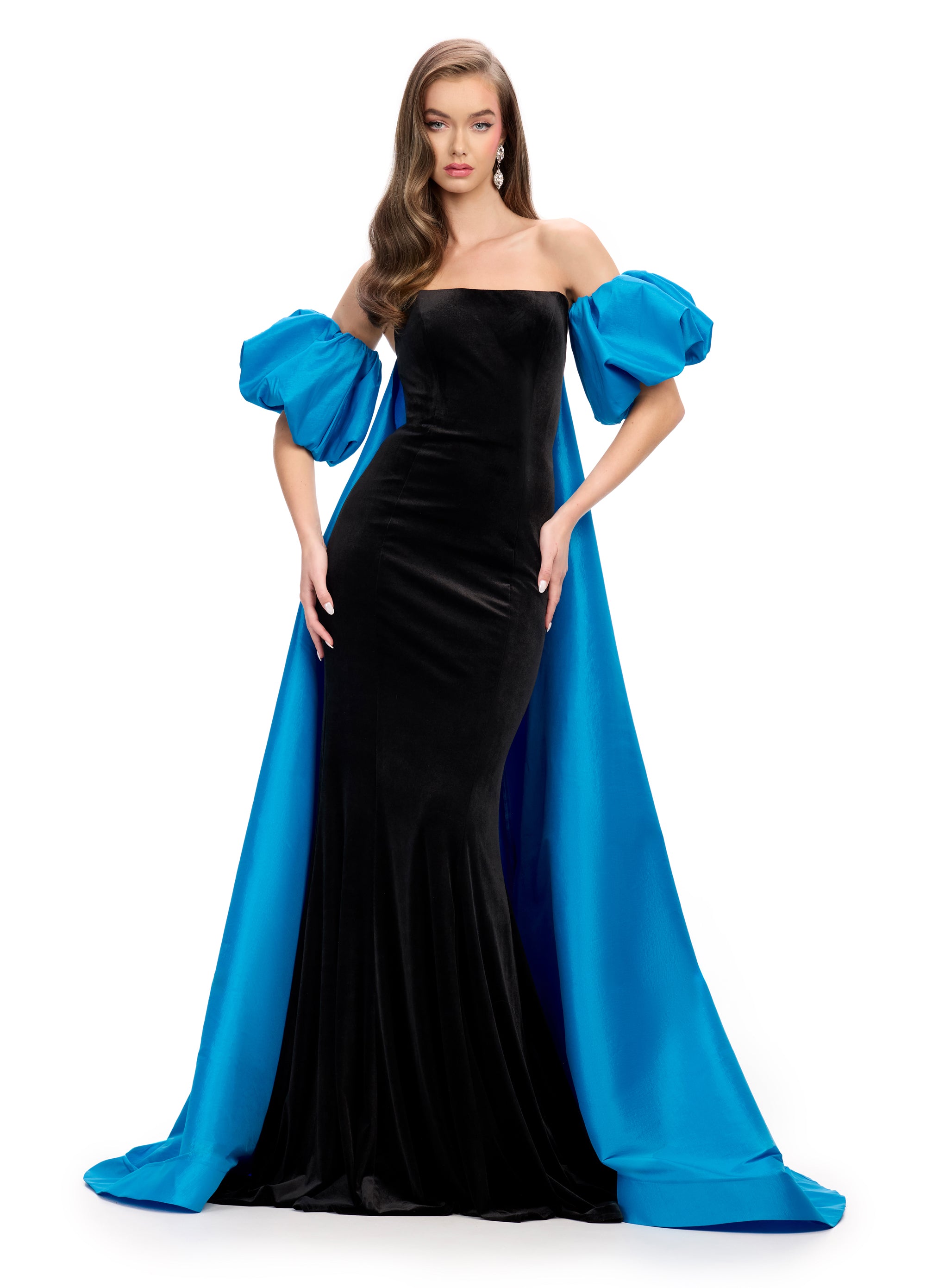 Elegant black strapless velvet gown with a fitted silhouette, bold blue off-shoulder puff sleeves, and a striking floor-length blue overskirt.