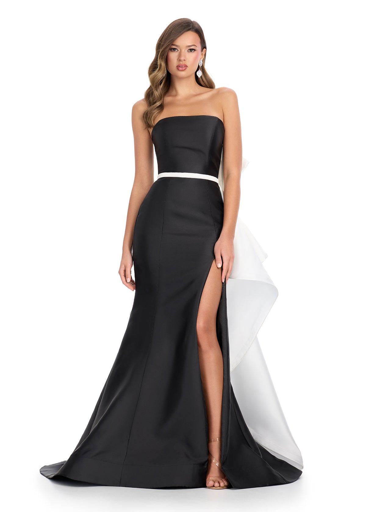 Elegant strapless gown with a sleek black silhouette, white waistband detail, and dramatic back ruffle cascading into a statement train.