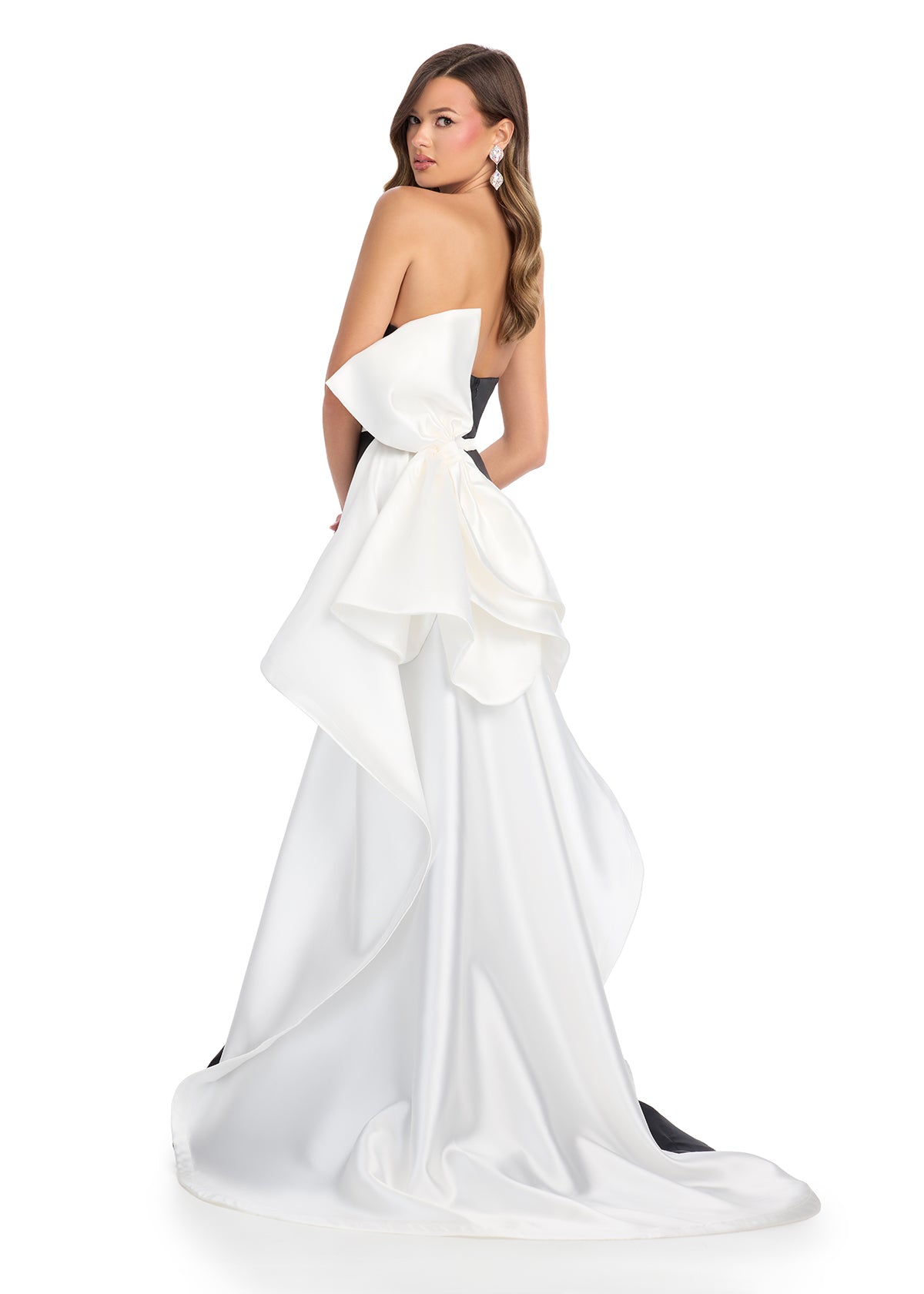 Back view - Elegant strapless gown with a sleek black silhouette, white waistband detail, and dramatic back ruffle cascading into a statement train.