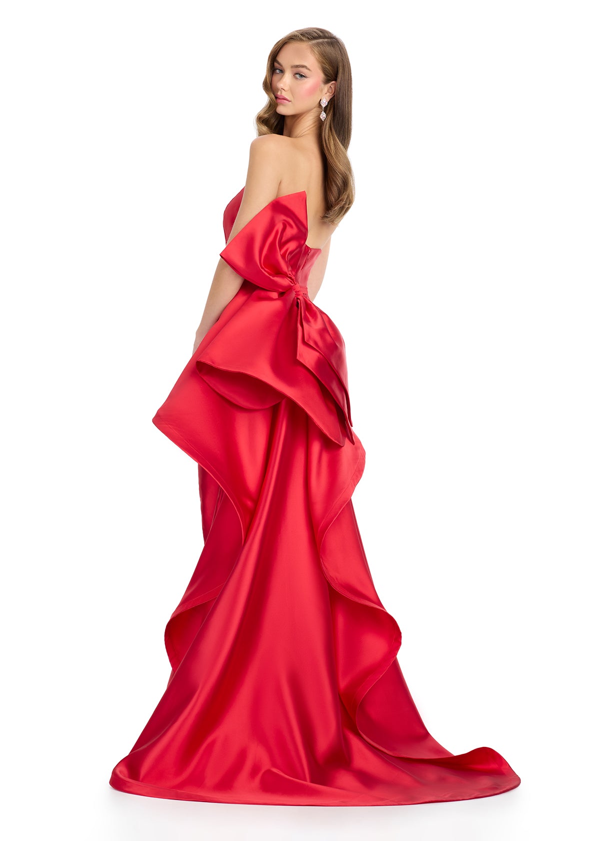 Back view -Elegant red strapless gown with a sleek black silhouette, white waistband detail, and dramatic back ruffle cascading into a statement train.