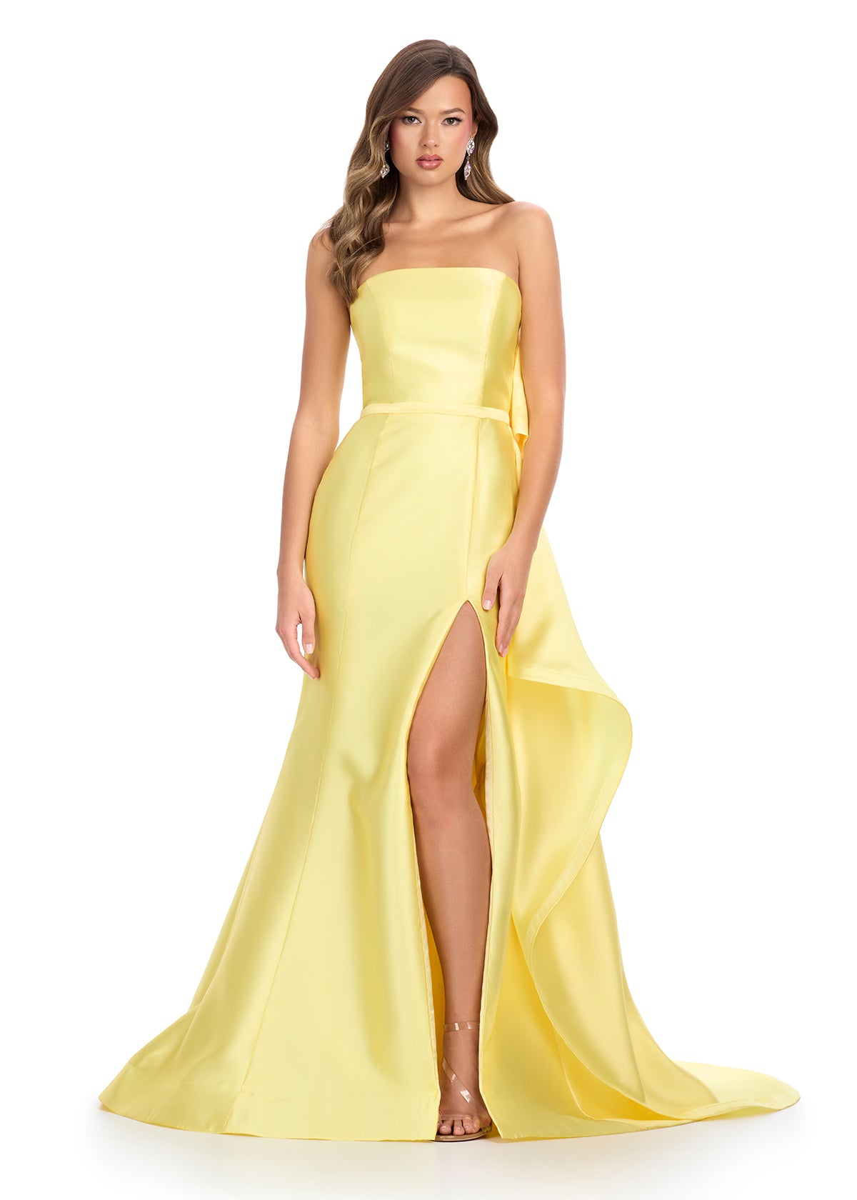 Elegant yellow strapless gown with a sleek black silhouette, white waistband detail, and dramatic back ruffle cascading into a statement train.