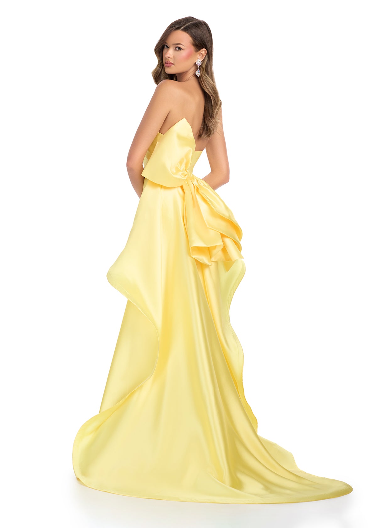 Back view - Elegant yellow strapless gown with a sleek black silhouette, white waistband detail, and dramatic back ruffle cascading into a statement train.