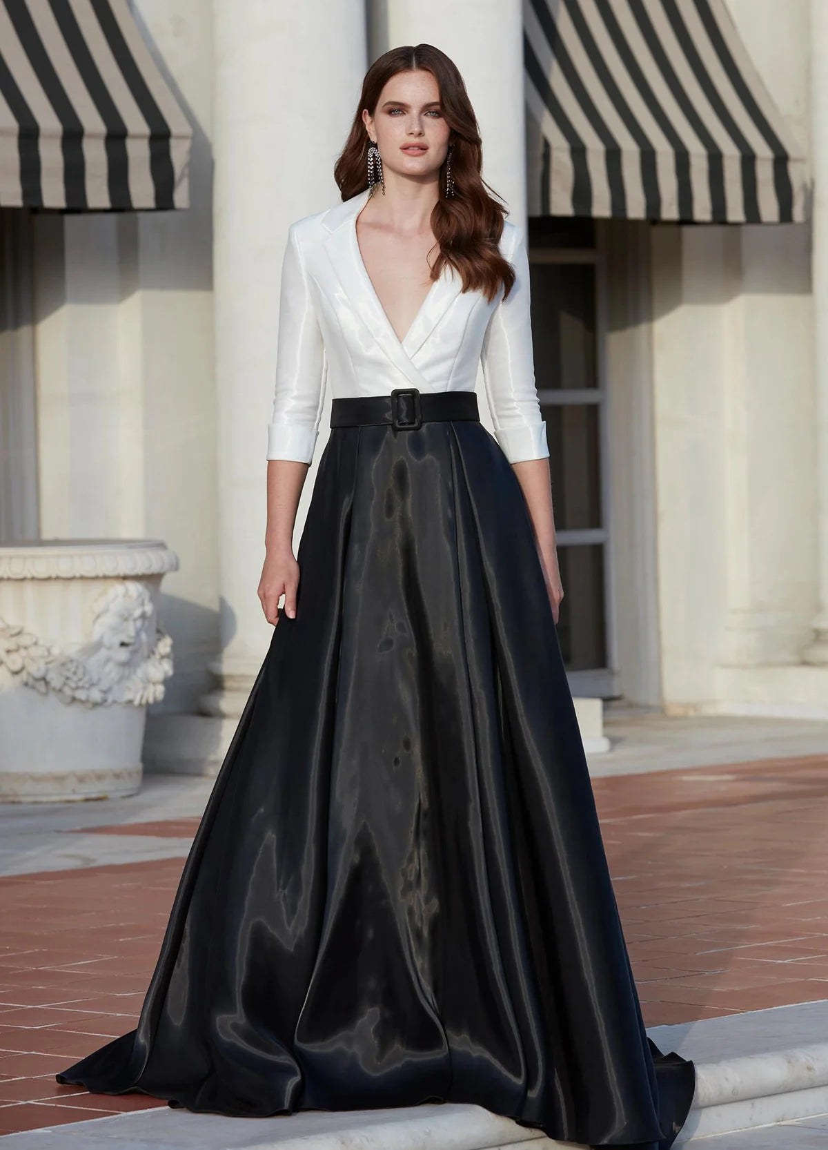 Video - Black and white gown with a tailored white plunging neckline bodice, three-quarter sleeves, and a voluminous black satin A-line skirt featuring a belted waist.